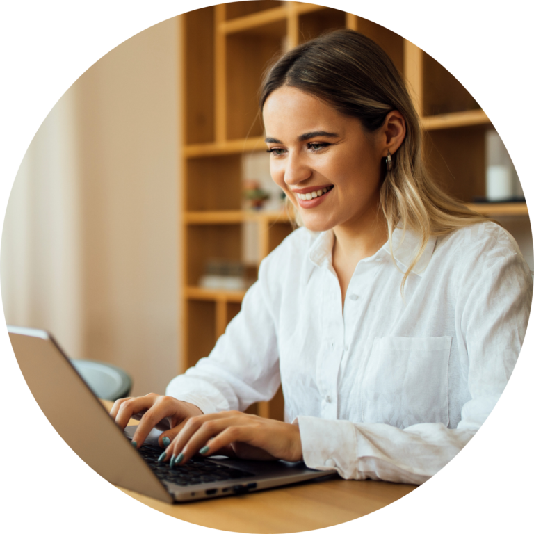ethnic lady in white collared shirt at home at a desk typing on laptop